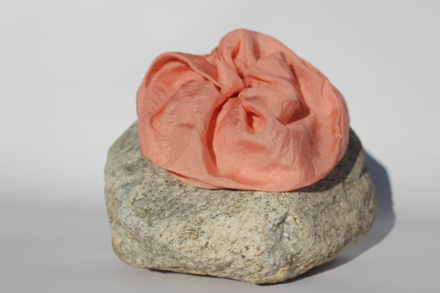 Pink silk scrunchie on a rock