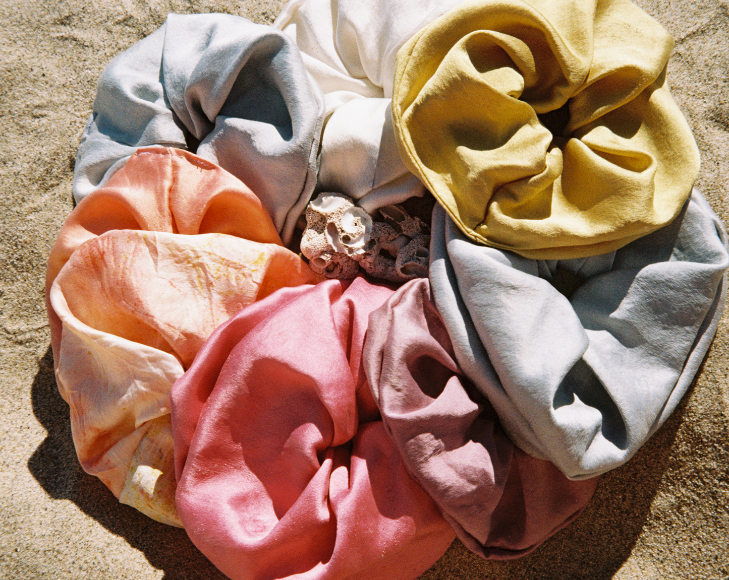 A rainbow circle of plant dyed silk scrunchies. Goose Summer.