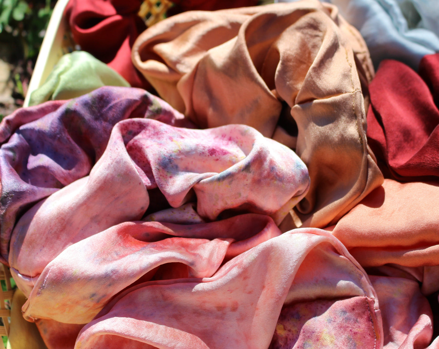 Close up shot of bubblegum pink silk scrunchies plant dyed in Los Angeles.