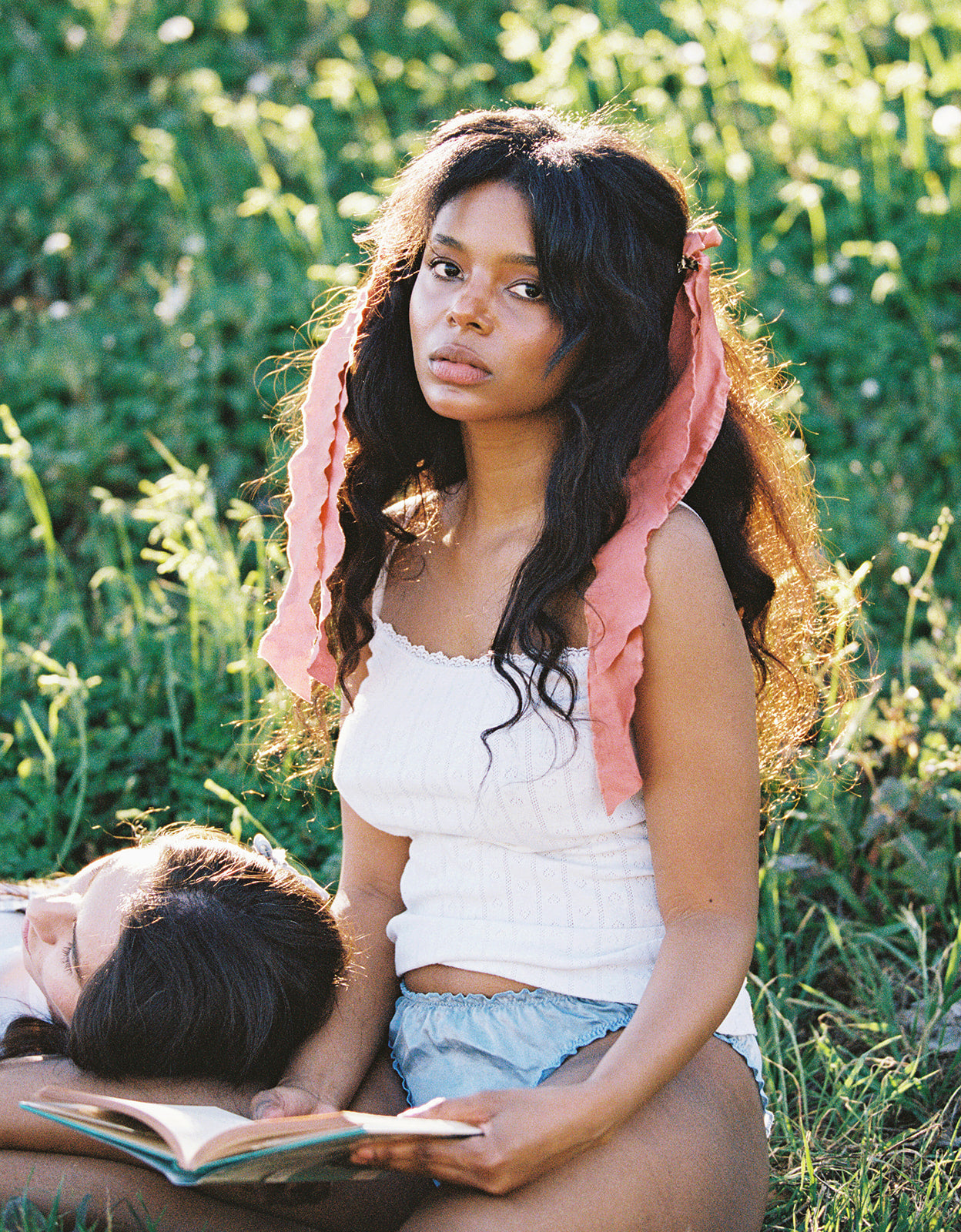 Woman sitting in the grass in blue silk undies made in LA