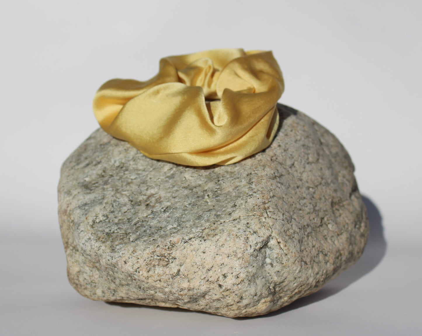  Yellow silk scrunchie on a rock