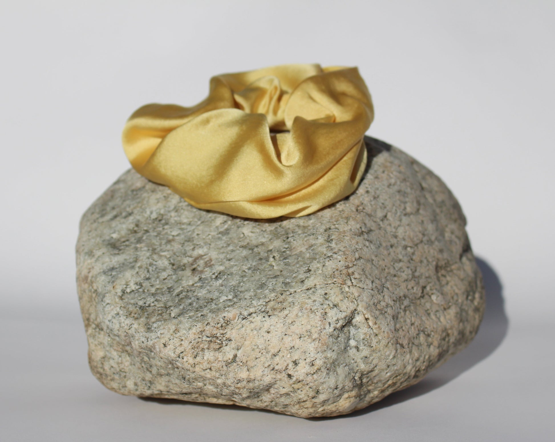  Yellow silk scrunchie on a rock