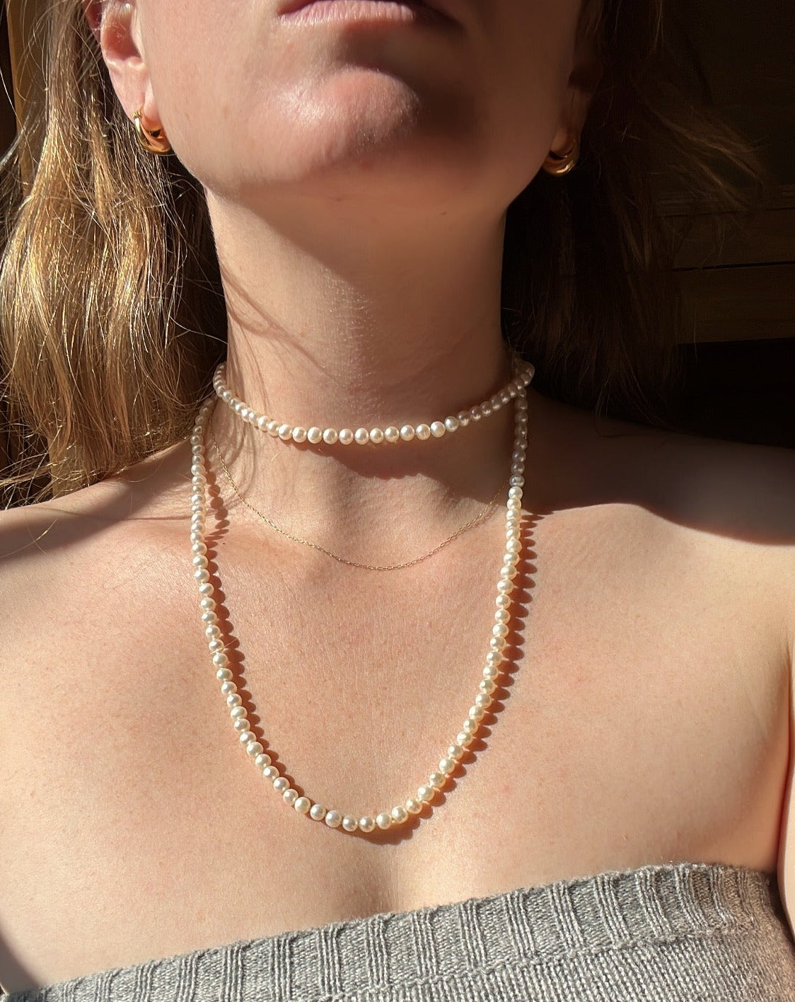 Vintage string of pearls worn by a woman