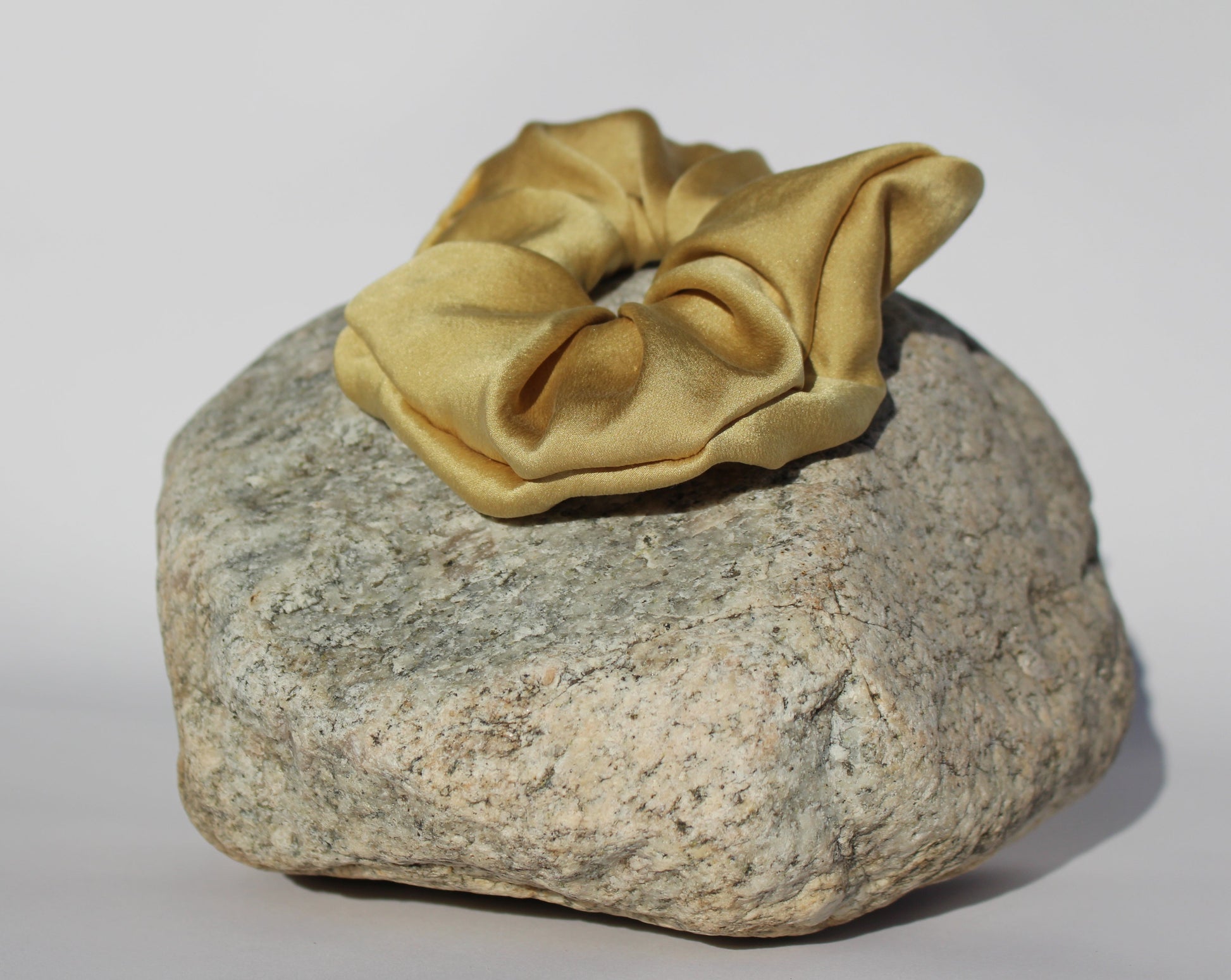 Gold silk scrunchie on a rock