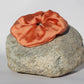 Peach colored silk scrunchie on a rock