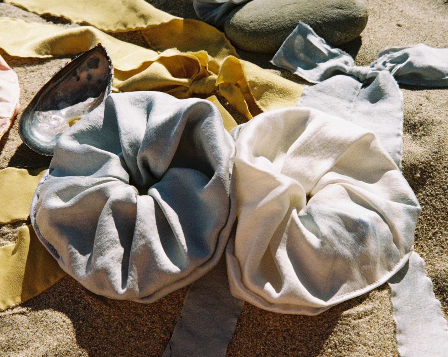 Two silk scrunchies side by side on the beach