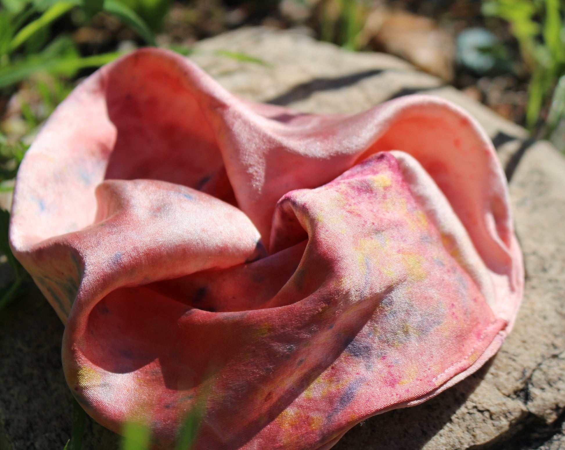 Close up shot of bubblegum pink silk scrunchies plant dyed in Los Angeles.