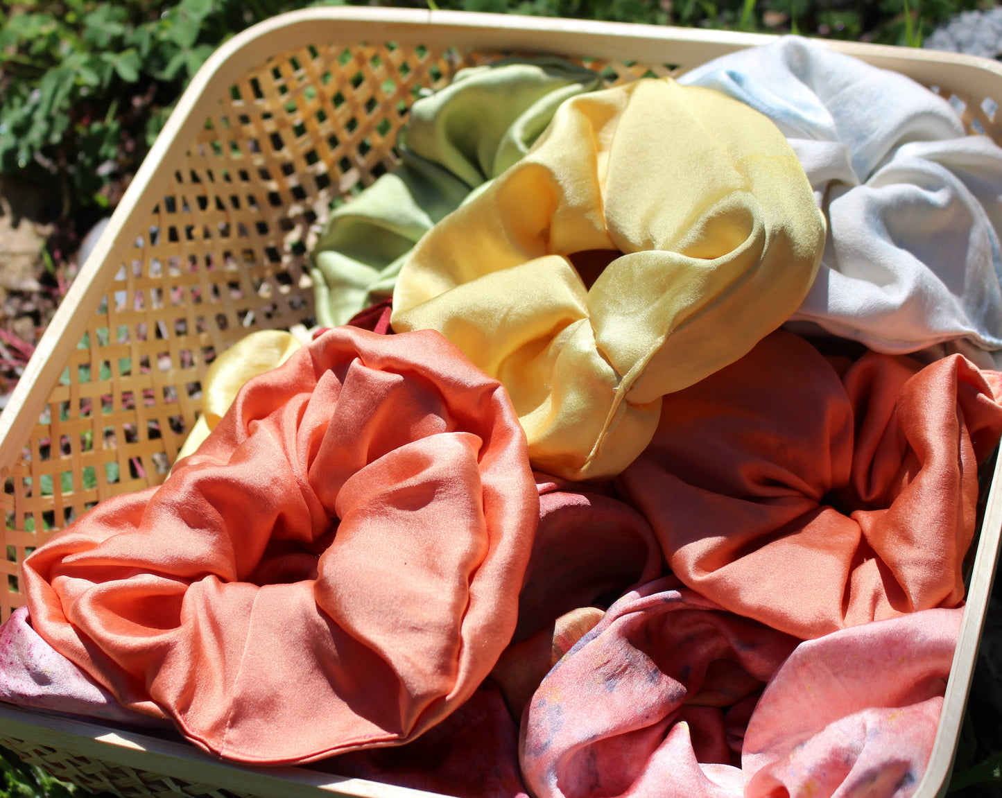 A basket full of silk plant dyed scrunchies 